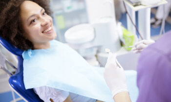 Image Text: Photograph of woman in dental chair for routine cleaning.