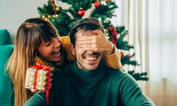 Image Text: woman giving man a present, maybe the gift of a new smile this New year, cosmetic dentistry